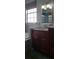 Bathroom with a marble counter, dark wood cabinets, bathtub, and a window for natural light at 3700 Plantation Blvd, Leesburg, FL 34748