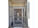 View through screened door to entry door and into the living area beyond with neutral walls and tile floors at 3700 Plantation Blvd, Leesburg, FL 34748