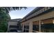 Exterior view of the home with a retractable awning, barbecue, and lush greenery at 3700 Plantation Blvd, Leesburg, FL 34748