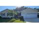Well-maintained single-story home featuring a manicured lawn, palm trees, and an attached two-car garage at 3700 Plantation Blvd, Leesburg, FL 34748