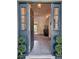 View through a welcoming entry door to the foyer and into the living area with neutral walls and tile floors at 3700 Plantation Blvd, Leesburg, FL 34748