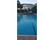 Full pool view showcasing its size, set against the backdrop of the clubhouse and manicured surroundings at 3700 Plantation Blvd, Leesburg, FL 34748