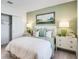 Calming bedroom features an inviting color scheme, a painting, and dressers on either side of the bed at 4760 Yellow Elder Way, Kissimmee, FL 34758