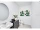 Charming powder room with round mirror, vessel sink and leafy decorations at 4760 Yellow Elder Way, Kissimmee, FL 34758