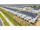 Aerial view of a community of modern townhomes with well-manicured lawns and landscaping at 502 Bogey Dr, Davenport, FL 33896