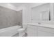 Modern bathroom features tiled shower and tub, white vanity, and a large mirror at 502 Bogey Dr, Davenport, FL 33896