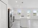 Bright, airy kitchen featuring white cabinets, stainless steel appliances, a center island, and an abundance of natural light at 502 Bogey Dr, Davenport, FL 33896