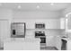 Bright kitchen features stainless steel appliances, white cabinetry, and a large countertop at 502 Bogey Dr, Davenport, FL 33896