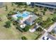 Community aerial view highlighting the pool, grilling area, and beautifully landscaped grounds between townhomes at 5214 Dragonfly Dr, Wildwood, FL 34785