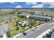 A high-angle shot showcasing a community swimming pool amidst townhomes and manicured green spaces at 5214 Dragonfly Dr, Wildwood, FL 34785