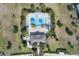 Overhead view of a community pool surrounded by palm trees, lounge chairs, and well-maintained landscaping at 5214 Dragonfly Dr, Wildwood, FL 34785