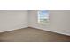 Bright, carpeted bedroom featuring a window with picturesque outside views at 5214 Dragonfly Dr, Wildwood, FL 34785