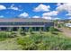 Exterior view of the back of modern townhomes, with a pond and lush landscaping, creating a peaceful setting at 5214 Dragonfly Dr, Wildwood, FL 34785