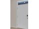 White front door with a digital lock and transom window providing secure access to the home at 5214 Dragonfly Dr, Wildwood, FL 34785