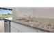 Close-up of kitchen sink and gray swirl granite countertops overlooking beautiful outdoor space at 5214 Dragonfly Dr, Wildwood, FL 34785