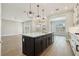Open kitchen with stainless steel appliances, island with pendant lighting, and wood-look tile flooring at 5242 Citrus Leaf, Winter Garden, FL 34787