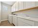 Bright laundry room features white cabinets, tile floors, sink, and modern washer and dryer at 5242 Citrus Leaf, Winter Garden, FL 34787
