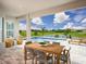 Inviting outdoor patio with dining table overlooking a pool, lake, and expansive views at 5242 Citrus Leaf, Winter Garden, FL 34787