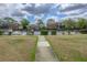 Sidewalk view of the community pool surrounded by iron fencing and low shrubs and lush grass at 5325 Curry Ford Rd # G202, Orlando, FL 32812