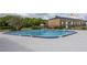 Community pool surrounded by a concrete deck and wrought iron fencing and brick building in background at 5325 Curry Ford Rd # G202, Orlando, FL 32812