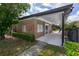 Brick building featuring a covered patio, green bushes, iron fencing, grass and sidewalks at 5325 Curry Ford Rd # G202, Orlando, FL 32812
