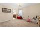 A simple bedroom setup with an exercise bike, window, and doorway to the bathroom at 7349 Ella Ln, Windermere, FL 34786