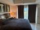 Comfortable bedroom with a large bed, neutral walls, and a sliding door to a balcony at 7518 Seven Eagles Way # 201, Reunion, FL 34747