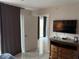 Bedroom with a dresser, wall-mounted TV, and doorway to a well-lit, airy outdoor area at 7518 Seven Eagles Way # 201, Reunion, FL 34747