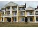 Exterior view of a yellow multi-story building with columns and white balconies at 7518 Seven Eagles Way # 201, Reunion, FL 34747