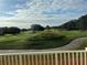 Scenic view of a lush green golf course with rolling hills and trees under a partly cloudy sky at 7518 Seven Eagles Way # 201, Reunion, FL 34747