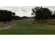 Scenic view of a lush green golf course with mature trees and rolling hills under a cloudy sky at 7518 Seven Eagles Way # 201, Reunion, FL 34747
