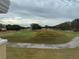 Picturesque view of the lush green golf course and distant trees with a paved sidewalk at 7518 Seven Eagles Way # 201, Reunion, FL 34747