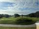 Scenic view of a lush green golf course with rolling hills and trees under a partly cloudy sky at 7518 Seven Eagles Way # 201, Reunion, FL 34747