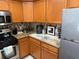 Kitchen with wood cabinets, stainless steel appliances, granite countertops and tiled backsplash at 7518 Seven Eagles Way # 201, Reunion, FL 34747