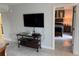 Living room view into the bedroom with a mounted tv and tiled floor at 7518 Seven Eagles Way # 201, Reunion, FL 34747