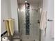 Shower with white tile, grey and black accents, and a glass door at 7518 Seven Eagles Way # 201, Reunion, FL 34747