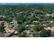 An aerial view showcases the community with mature landscaping and nearby city skyline and water tower at 7703 Pine Vista Ct, Orlando, FL 32819