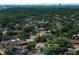 An aerial view showcases the community with mature landscaping, nearby city skyline, and a red pin at 7703 Pine Vista Ct, Orlando, FL 32819