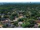 An aerial view showcases the community with mature landscaping and nearby city skyline at 7703 Pine Vista Ct, Orlando, FL 32819