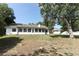 Spacious backyard with green grass, mature trees, and view of home's enclosed sunroom at 7703 Pine Vista Ct, Orlando, FL 32819
