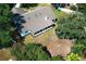 Aerial view of a backyard with a screened-in porch, mature landscaping, and a white exterior at 7703 Pine Vista Ct, Orlando, FL 32819