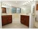 Bathroom featuring dual wooden vanities, large mirrors, and tile flooring at 7703 Pine Vista Ct, Orlando, FL 32819