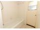 Clean and simple bathroom featuring a tub, shower and a window near the door at 7703 Pine Vista Ct, Orlando, FL 32819