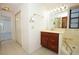 Well-lit bathroom with a wooden vanity and white tile flooring at 7703 Pine Vista Ct, Orlando, FL 32819