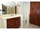 Bathroom showcasing a marble countertop vanity, toilet and wooden cabinets at 7703 Pine Vista Ct, Orlando, FL 32819