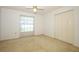 Bedroom features a ceiling fan, carpet, closet, and a window at 7703 Pine Vista Ct, Orlando, FL 32819