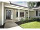 Inviting front porch with white columns, a decorative glass front door, and manicured landscaping at 7703 Pine Vista Ct, Orlando, FL 32819