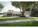 Charming one-story home with a well-maintained lawn, mature trees, and an attached two-car garage at 7703 Pine Vista Ct, Orlando, FL 32819