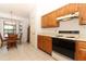 Eat-in kitchen with wood cabinets, tile flooring and modern appliances at 7703 Pine Vista Ct, Orlando, FL 32819