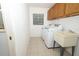 Efficient laundry room with appliances, sink, storage, and tile floors at 7703 Pine Vista Ct, Orlando, FL 32819